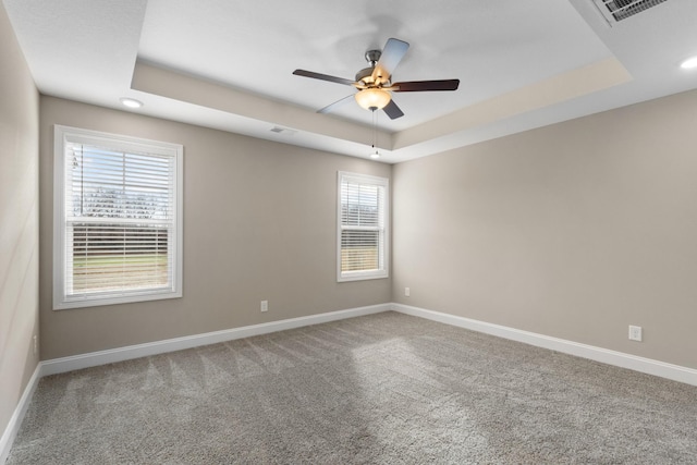 unfurnished room with carpet floors, a raised ceiling, and ceiling fan