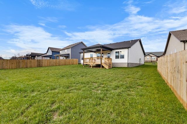 rear view of house featuring a lawn and a deck