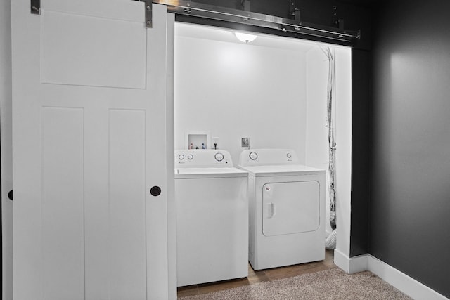 washroom with a barn door and separate washer and dryer