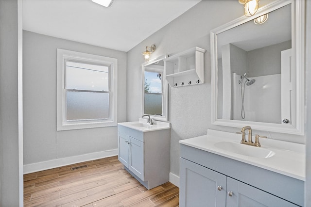 bathroom featuring walk in shower, vanity, and hardwood / wood-style flooring