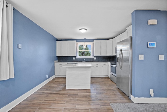 kitchen featuring appliances with stainless steel finishes, a center island, light hardwood / wood-style flooring, and white cabinetry