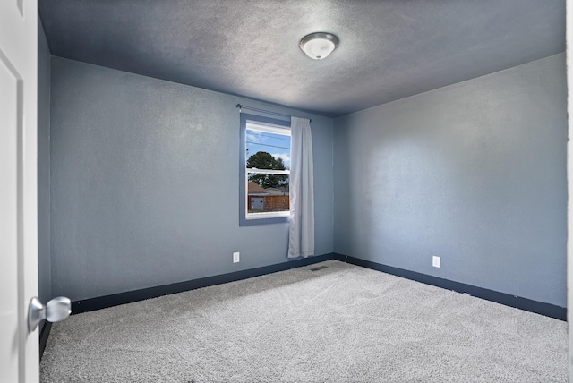 empty room featuring carpet flooring and a textured ceiling