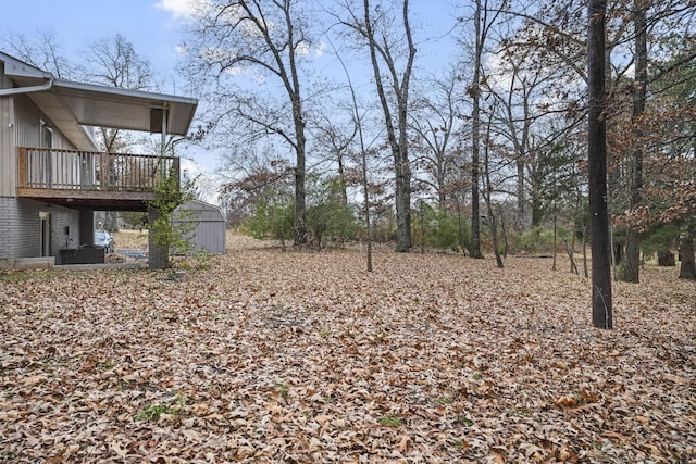 view of yard featuring a storage unit and a deck