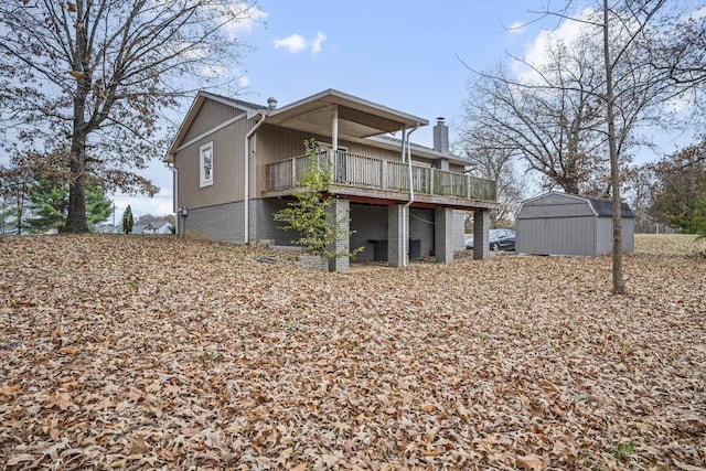 rear view of property with a deck and a storage shed