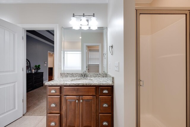 bathroom featuring tile patterned floors, crown molding, vanity, and an enclosed shower