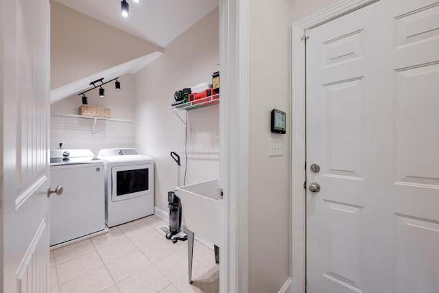 washroom with washing machine and dryer and light tile patterned floors