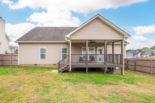 rear view of property with a lawn, a wooden deck, and ceiling fan