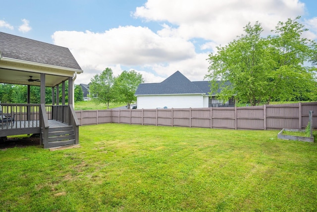 view of yard featuring ceiling fan and a deck