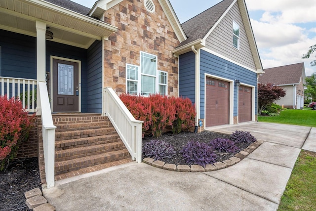 view of front of house featuring concrete driveway, stone siding, and a garage