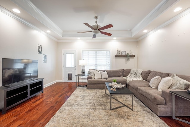 living area featuring a tray ceiling, ceiling fan, dark wood-style floors, ornamental molding, and recessed lighting