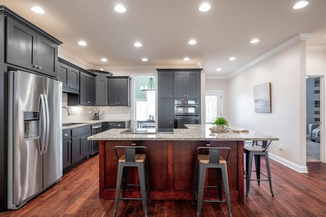 kitchen featuring appliances with stainless steel finishes, crown molding, a sink, dark wood-type flooring, and light stone counters