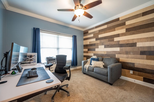 carpeted home office featuring ceiling fan, wood walls, an accent wall, ornamental molding, and baseboards