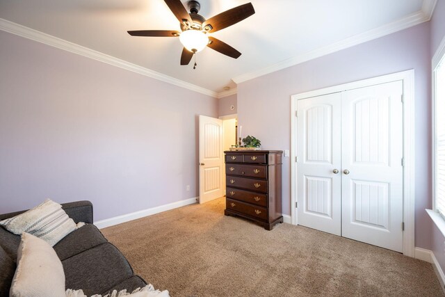 living area with ornamental molding, light colored carpet, a ceiling fan, and baseboards