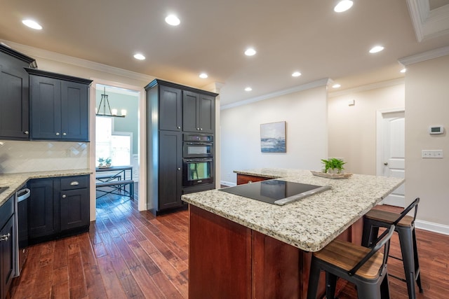 kitchen featuring ornamental molding, dark wood-type flooring, black appliances, a center island, and tasteful backsplash