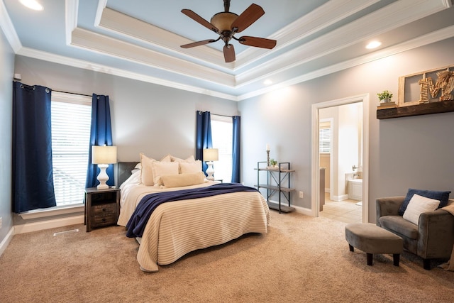 bedroom featuring carpet flooring, multiple windows, a tray ceiling, ornamental molding, and ensuite bath
