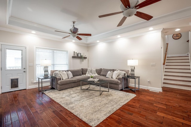 living area with a ceiling fan, stairway, dark wood-style floors, baseboards, and a tray ceiling