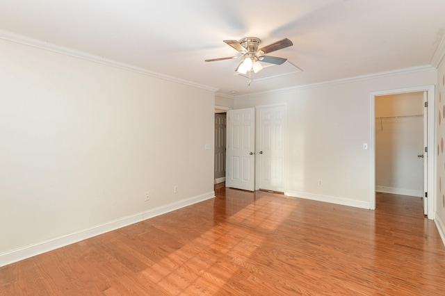 empty room with ornamental molding, ceiling fan, and light hardwood / wood-style flooring