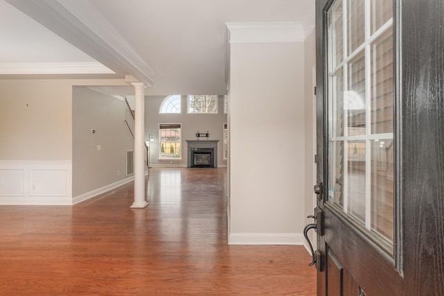 entryway featuring crown molding, wood-type flooring, and ornate columns