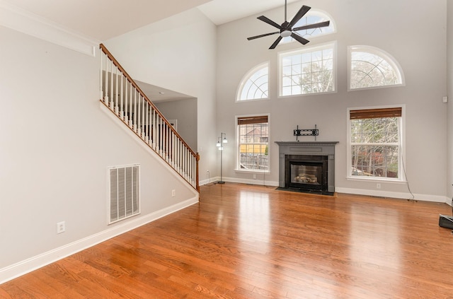 unfurnished living room featuring plenty of natural light, ceiling fan, and light wood-type flooring