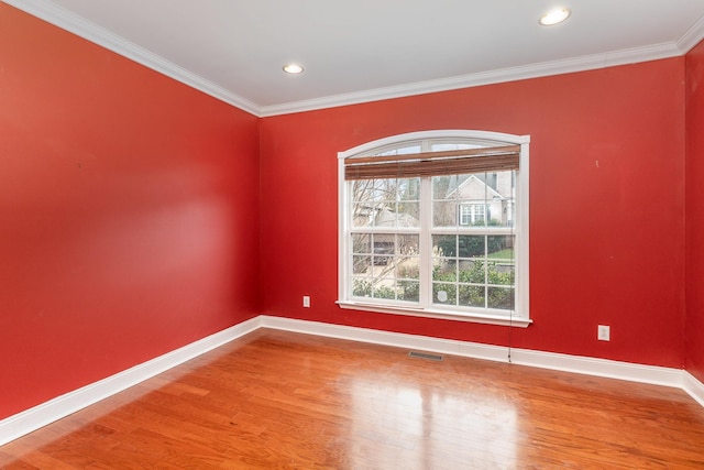 spare room featuring crown molding and hardwood / wood-style flooring