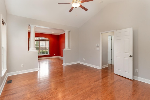 unfurnished room featuring hardwood / wood-style floors, high vaulted ceiling, ceiling fan, and ornate columns