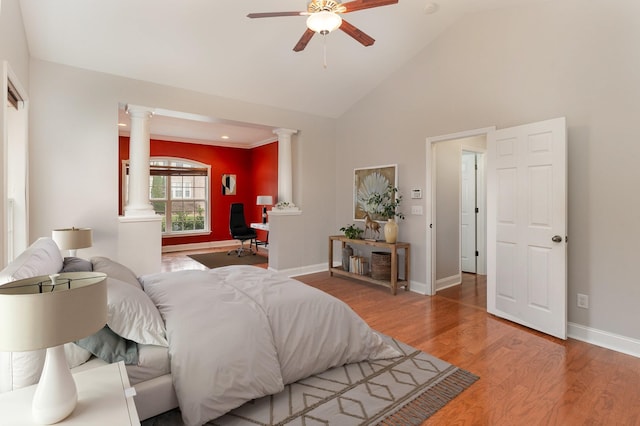 bedroom with hardwood / wood-style flooring, high vaulted ceiling, and decorative columns