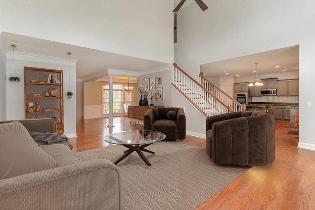 living room featuring ornamental molding, a chandelier, and light hardwood / wood-style floors