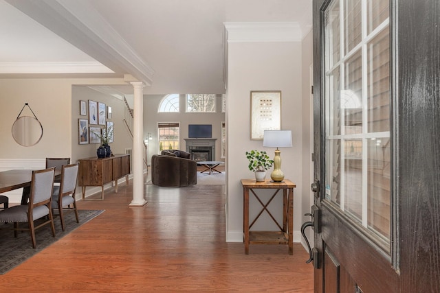 entrance foyer featuring decorative columns, crown molding, and hardwood / wood-style floors