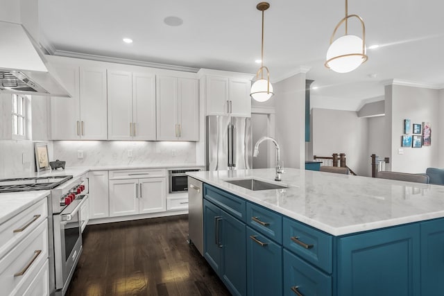 kitchen with high end appliances, dark wood-type flooring, sink, blue cabinetry, and wall chimney range hood