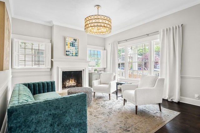 sitting room with a notable chandelier, dark hardwood / wood-style flooring, and ornamental molding