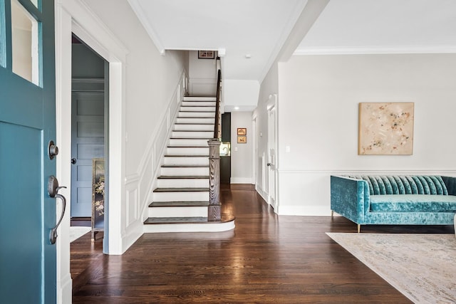 entrance foyer with dark hardwood / wood-style floors and crown molding