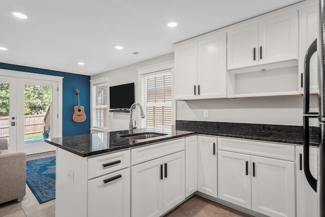 kitchen with french doors, plenty of natural light, dark stone counters, and sink