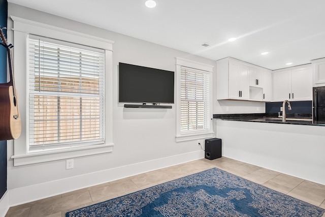 kitchen featuring white cabinetry, sink, and light tile patterned floors