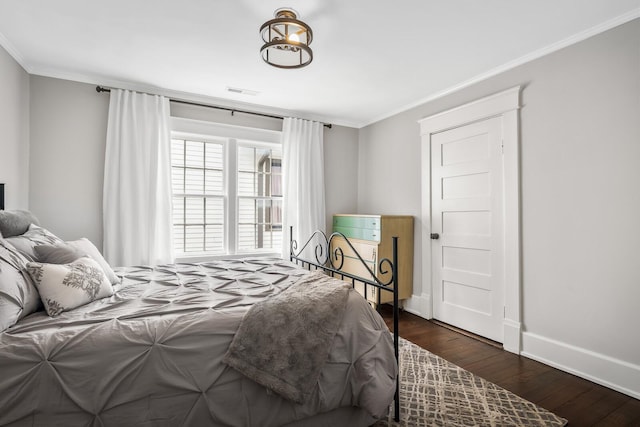 bedroom with dark hardwood / wood-style flooring and ornamental molding