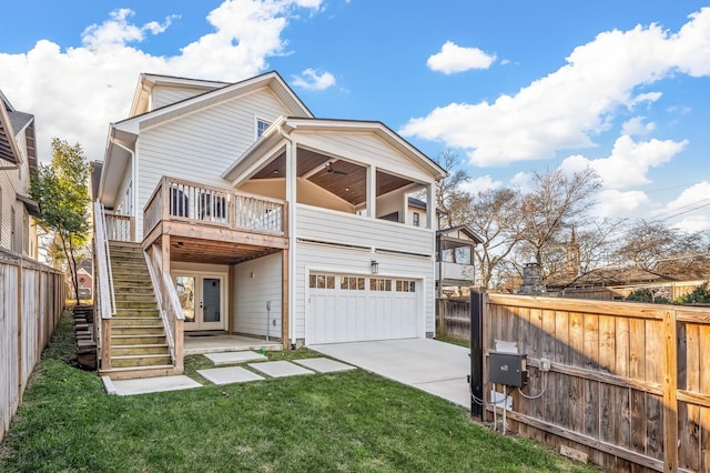 back of property featuring a garage, a deck, and a lawn