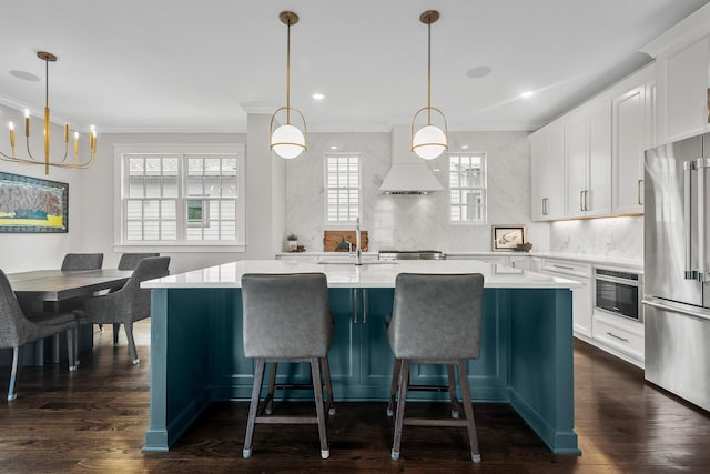 kitchen with custom range hood, stainless steel appliances, dark wood-type flooring, decorative light fixtures, and a kitchen island