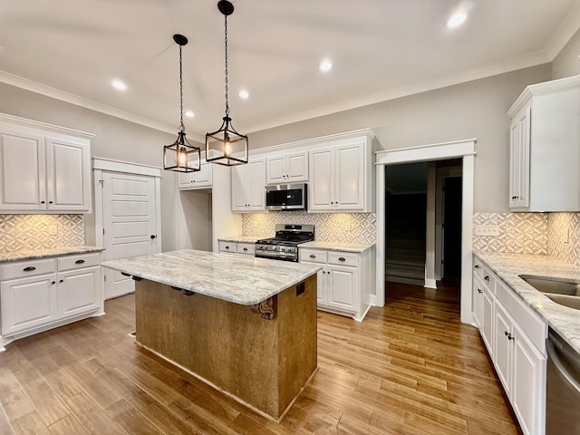 kitchen with white cabinets, light wood-type flooring, a center island, and stainless steel appliances