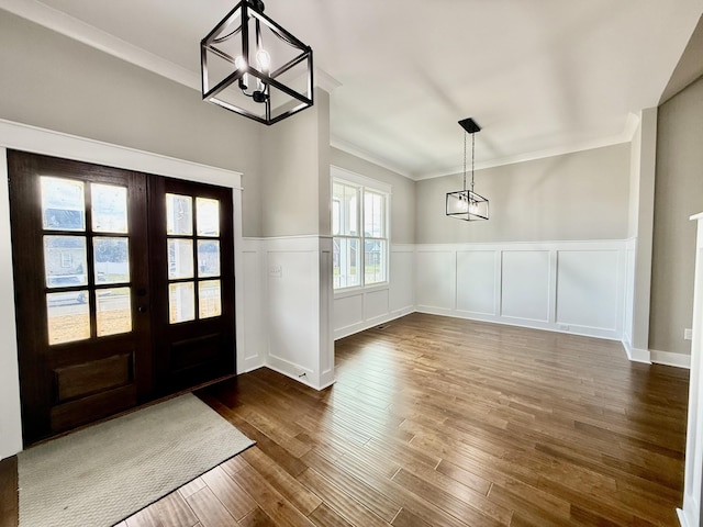 entryway featuring dark hardwood / wood-style flooring, crown molding, plenty of natural light, and french doors