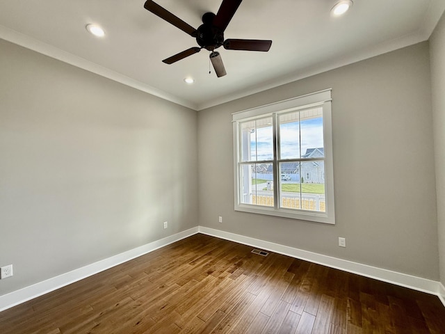 empty room featuring dark hardwood / wood-style flooring, ceiling fan, and ornamental molding