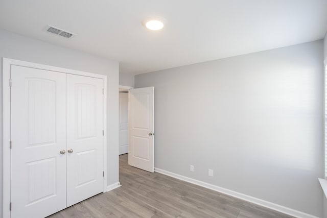 unfurnished bedroom featuring light hardwood / wood-style floors and a closet