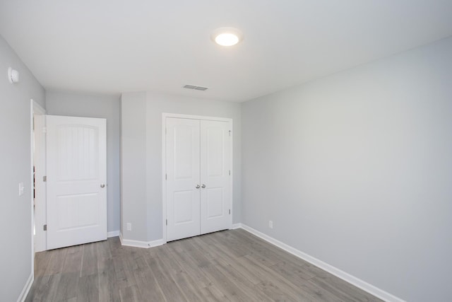 unfurnished bedroom featuring light hardwood / wood-style flooring and a closet