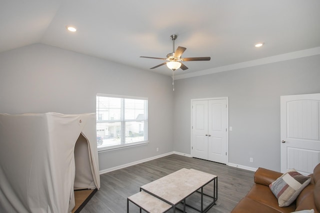 living room featuring ceiling fan, dark wood-type flooring, and vaulted ceiling