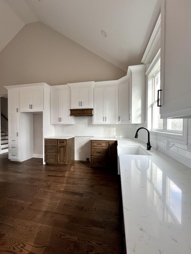 kitchen featuring sink, tasteful backsplash, high vaulted ceiling, dark hardwood / wood-style floors, and white cabinets