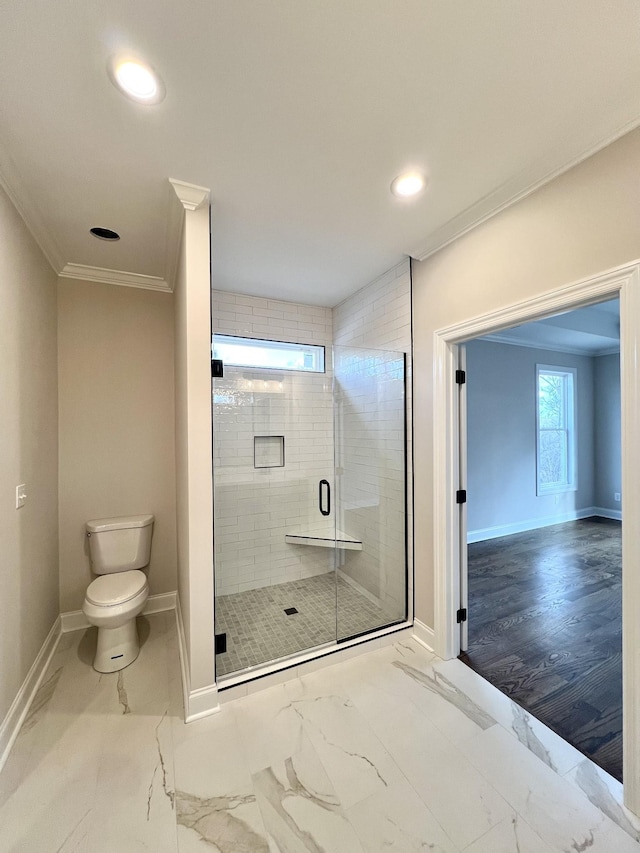 bathroom featuring hardwood / wood-style floors, toilet, a shower with door, and crown molding