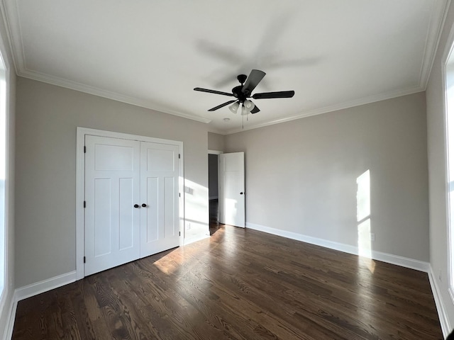 unfurnished bedroom featuring ceiling fan, a closet, dark hardwood / wood-style floors, and ornamental molding