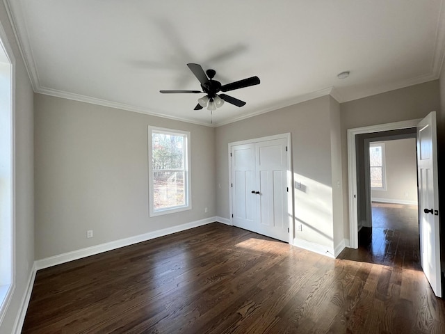 unfurnished bedroom featuring a closet, dark hardwood / wood-style floors, ceiling fan, and crown molding