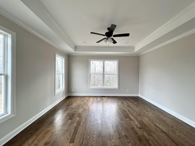 unfurnished room with a tray ceiling, ceiling fan, dark hardwood / wood-style flooring, and ornamental molding