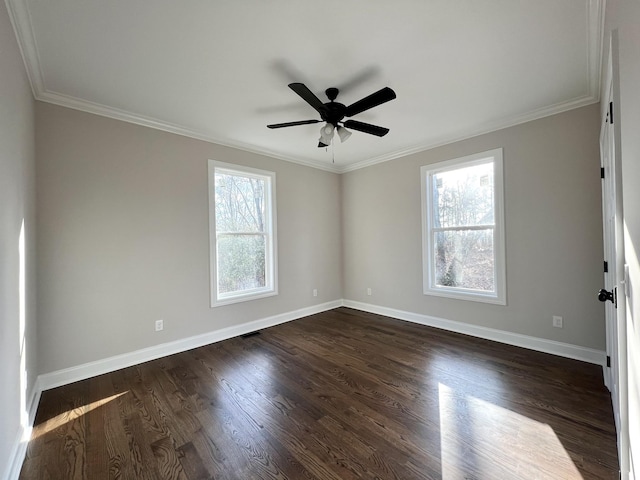 empty room with a healthy amount of sunlight, ornamental molding, and dark wood-type flooring