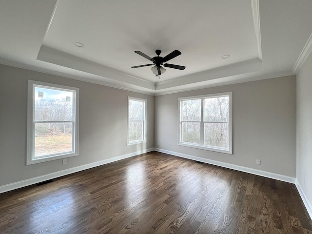 spare room featuring ceiling fan, dark hardwood / wood-style flooring, ornamental molding, and a tray ceiling