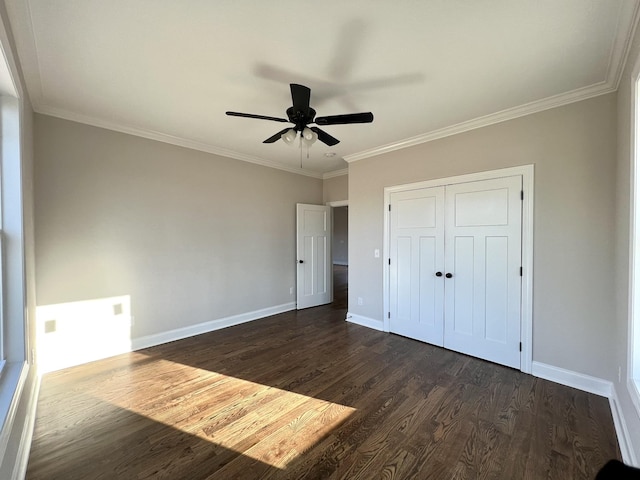 unfurnished bedroom with dark hardwood / wood-style flooring, a closet, ceiling fan, and crown molding